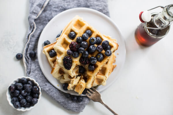 Homemade waffles overhead shot on white background with maple syrup