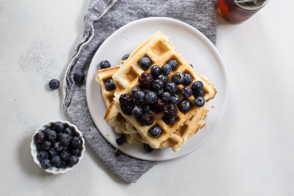 gluten free waffles on white plate with blueberries