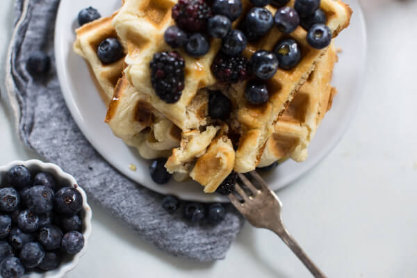 overhead bite shot of homemade gluten free waffles with blueberries