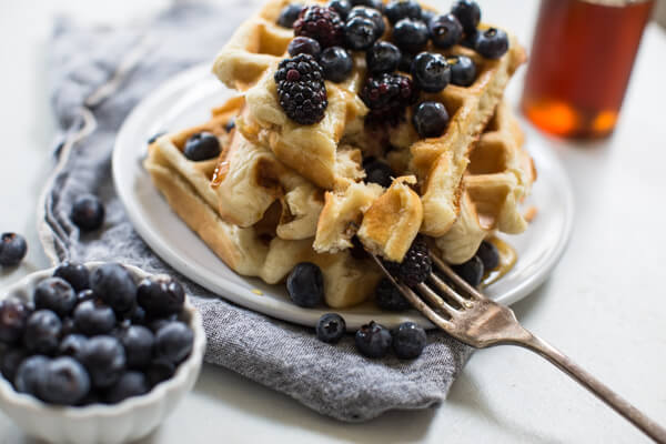 close up bite shot of homemade buttermilk waffles with blueberries