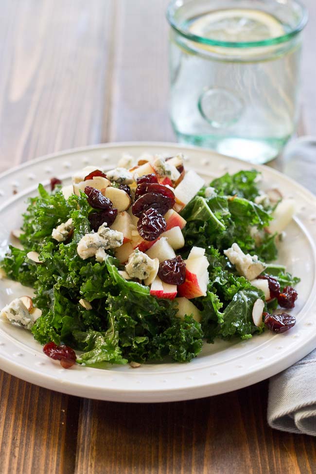 Refreshing Apple & Kale Power Salad topped with tart cherries, almonds, blue cheese, and perfectly dressed with apple maple vinaigrette!