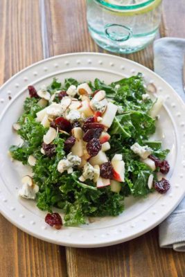 Refreshing Apple & Kale Power Salad topped with tart cherries, almonds, blue cheese, and perfectly dressed with apple maple vinaigrette!