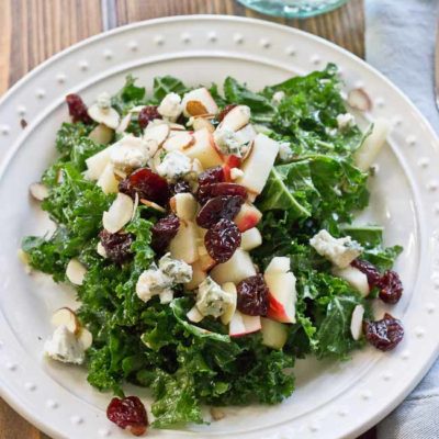 Refreshing Apple & Kale Power Salad topped with tart cherries, almonds, blue cheese, and perfectly dressed with apple maple vinaigrette!