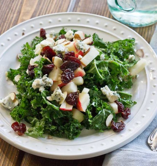 Refreshing Apple & Kale Power Salad topped with tart cherries, almonds, blue cheese, and perfectly dressed with apple maple vinaigrette!