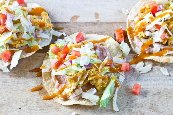 Slow Cooker BBQ Chicken Tostadas-- pulled chicken breast cooked with Trader Joe's famous Carolina Gold BBQ Sauce topped on crispy baked tostadas and veggies. This weeknight dinner will quickly become a family favorite. High protein and gluten-free.| @KristinaLaRueRD | loveandzest.com