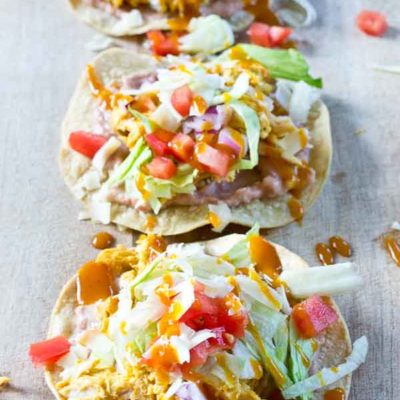 Slow Cooker BBQ Chicken Tostadas-- pulled chicken breast cooked with Trader Joe's famous Carolina Gold BBQ Sauce topped on crispy baked tostadas and veggies. This weeknight dinner will quickly become a family favorite. High protein and gluten-free.| @KristinaLaRueRD | loveandzest.com