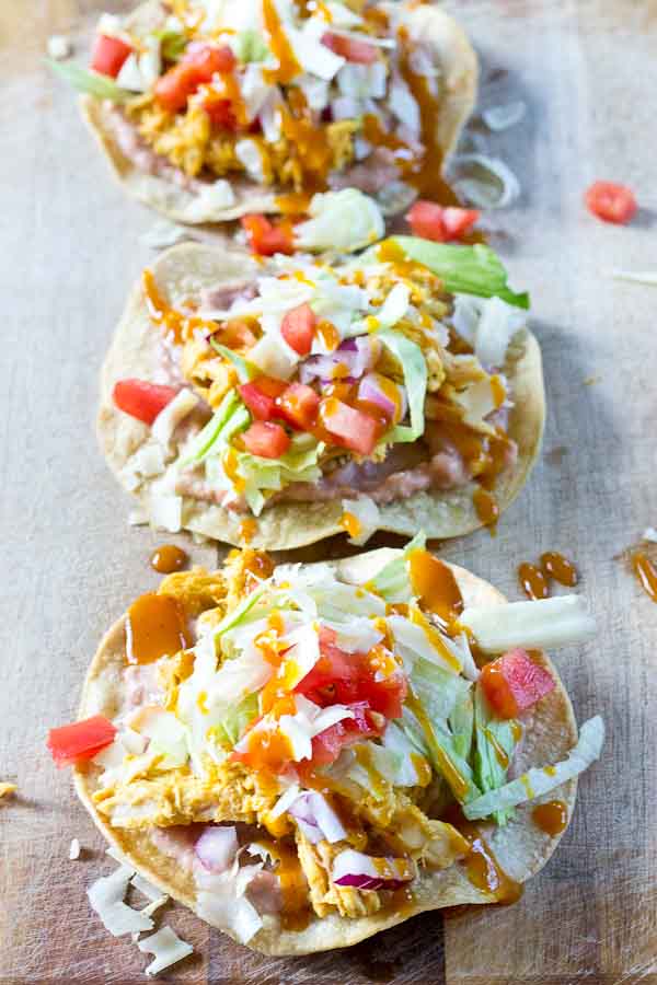 Slow Cooker BBQ Chicken Tostadas-- pulled chicken breast cooked with Trader Joe's famous Carolina Gold BBQ Sauce topped on crispy baked tostadas and veggies. This weeknight dinner will quickly become a family favorite. High protein and gluten-free.| @KristinaLaRueRD | loveandzest.com