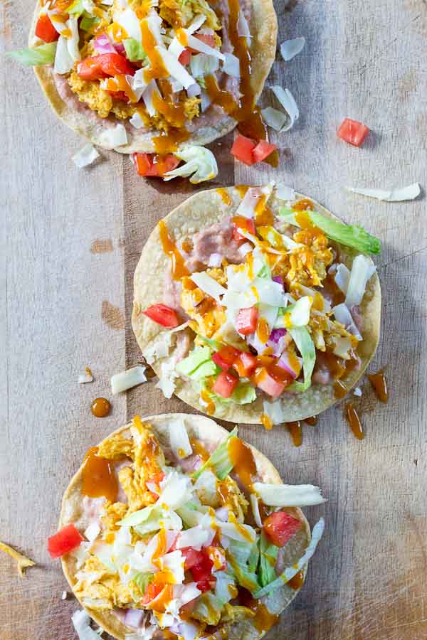 Slow Cooker BBQ Chicken Tostadas-- pulled chicken breast cooked with Trader Joe's famous Carolina Gold BBQ Sauce topped on crispy baked tostadas and veggies. This weeknight dinner will quickly become a family favorite. High protein and gluten-free.| @KristinaLaRueRD | loveandzest.com