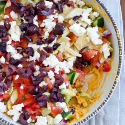 This Greek 7 Layer Dip is loaded with only the good stuff-- roasted red pepper hummus and loads of veggies. Perfect appetizer to serve at any party.