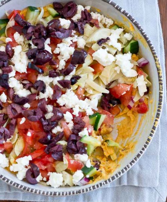 This Greek 7 Layer Dip is loaded with only the good stuff-- roasted red pepper hummus and loads of veggies. Perfect appetizer to serve at any party. 