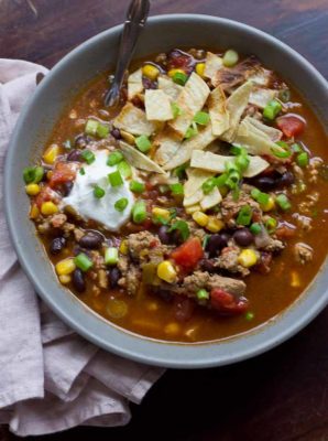 This Turkey Taco Soup is easy peasy to make for a weeknight dinner... a healthy meal the whole family will enjoy. Toss all ingredients into a pot and simmer until you're ready to eat! The toppings are the best part! | @KristinaLaRueRD | www.loveandzest.com