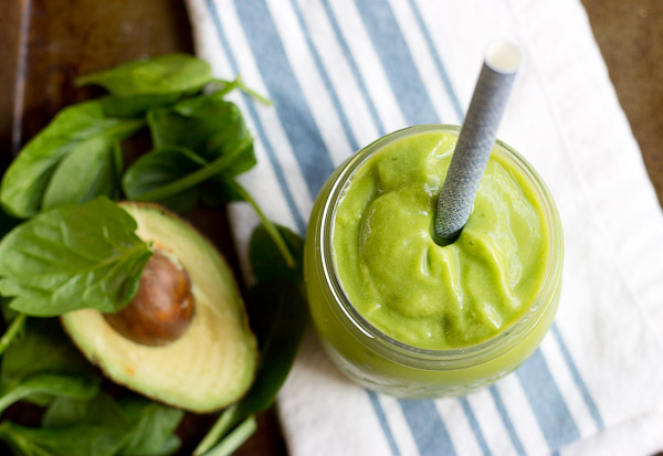 overhead shot of avocado green smoothie with straw