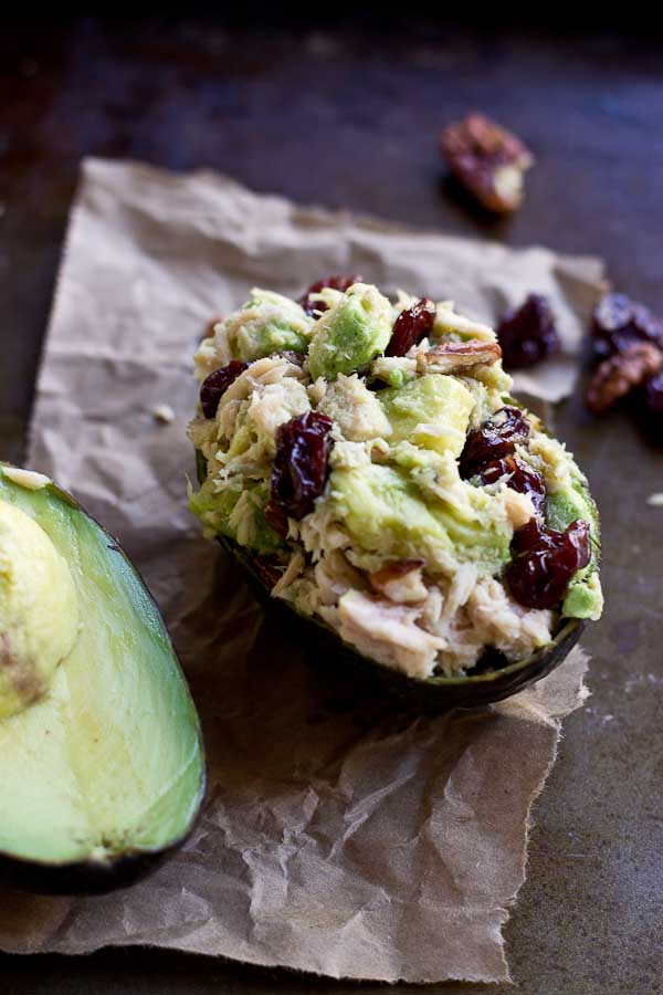 close up of tuna stuffed avocado with cherries and pecans 