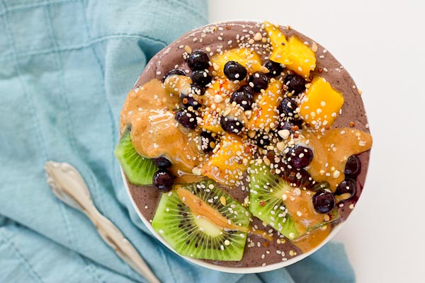 With summer quickly approaching, this superfood smoothie bowl will keep you cool and fueled on the sunniest days. Wild blueberries, spinach, avocado, and flaxmilk combine to form a creamy, antioxidant-packed bowl that is vegan and gluten-free! Slices of fresh kiwi and a drizzle of almond butter make this smoothie bowl practically irresistible.
