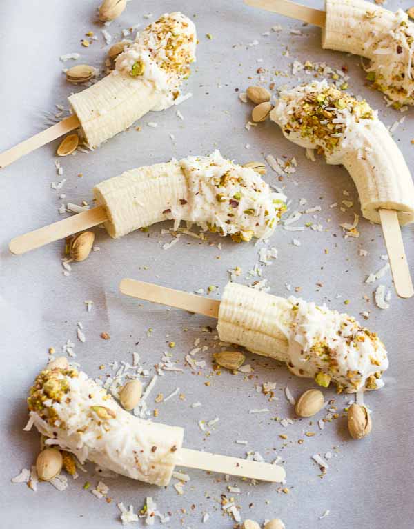  These Banana Crunch Pops are just what you need on a hot summer day, kids and adults rejoice! Only 4 ingredients and very simple to make! Place banana on stick, dunk in Greek yogurt and roll in pistachios and shredded coconut and freeze.