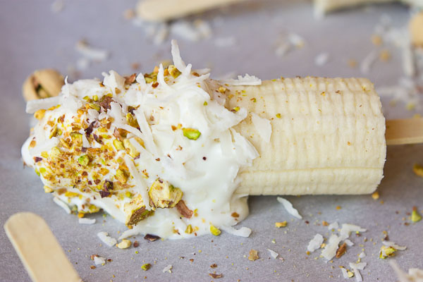  These Banana Crunch Pops are just what you need on a hot summer day, kids and adults rejoice! Only 4 ingredients and very simple to make! Place banana on stick, dunk in Greek yogurt and roll in pistachios and shredded coconut and freeze.