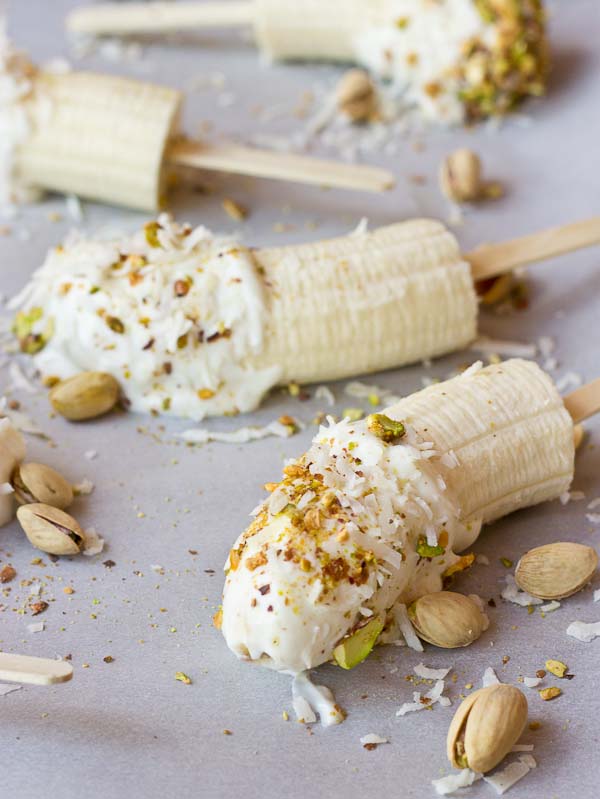  These Banana Crunch Pops are just what you need on a hot summer day, kids and adults rejoice! Only 4 ingredients and very simple to make! Place banana on stick, dunk in Greek yogurt and roll in pistachios and shredded coconut and freeze.