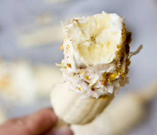  These Banana Crunch Pops are just what you need on a hot summer day, kids and adults rejoice! Only 4 ingredients and very simple to make! Place banana on stick, dunk in Greek yogurt and roll in pistachios and shredded coconut and freeze.