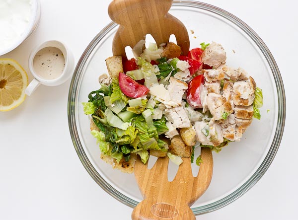 If you love chopped meal salads this Grilled Greens Chicken Caesar Chopped Salad is for you! A healthy caesar salad made with grilled romaine, grilled chicken breast, sweet tomatoes, homemade croutons, and zesty Greek yogurt caesar dressing