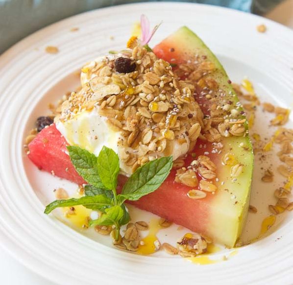 This Watermelon Breakfast Pizza is so it guys! Slice of watermelon, topped with Greek yogurt, seeds, and a drizzle of honey. Make it your own by adding your favorite toppings. The possibilities are endless.