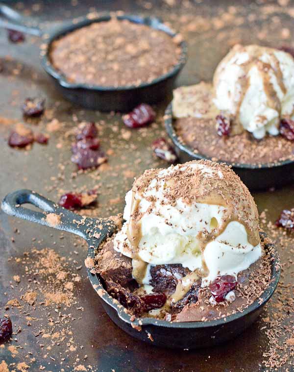 Double Chocolate Cherry Skillet Brownies a la mode with vanilla ice cream, almond butter drizzle, and chocolate shavings. This skillet brownie is lower in sugar and made with healthier ingredients like almond butter, whole grains, dried Montmorency tart cherries, and dark chocolate. 