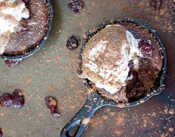 Double Chocolate Cherry Skillet Brownies a la mode with vanilla ice cream, almond butter drizzle, and chocolate shavings. This skillet brownie is lower in sugar and made with healthier ingredients like almond butter, whole grains, dried Montmorency tart cherries, and dark chocolate. 