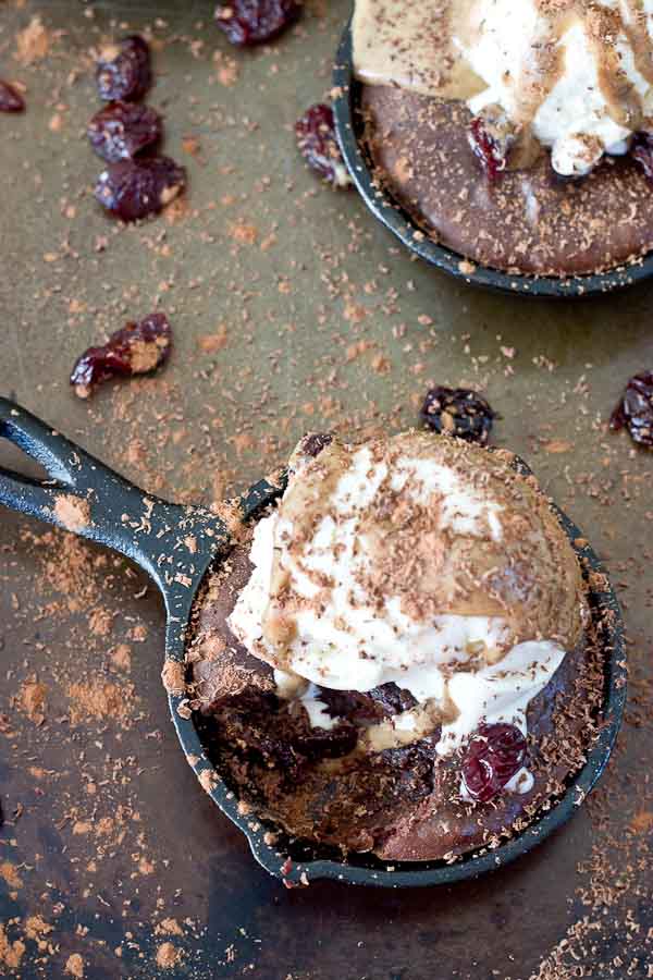 Double Chocolate Cherry Skillet Brownies a la mode with vanilla ice cream, almond butter drizzle, and chocolate shavings. This skillet brownie is lower in sugar and made with healthier ingredients like almond butter, whole grains, dried Montmorency tart cherries, and dark chocolate. 