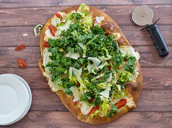 Get your Kale Caesar Salad Pizza on!! This pizza will be the talk of the town, a delicious Pizza blanca with roasted tomatoes, garlic and fresh mozzarella topped with loads of Kale Caesar Salad. 