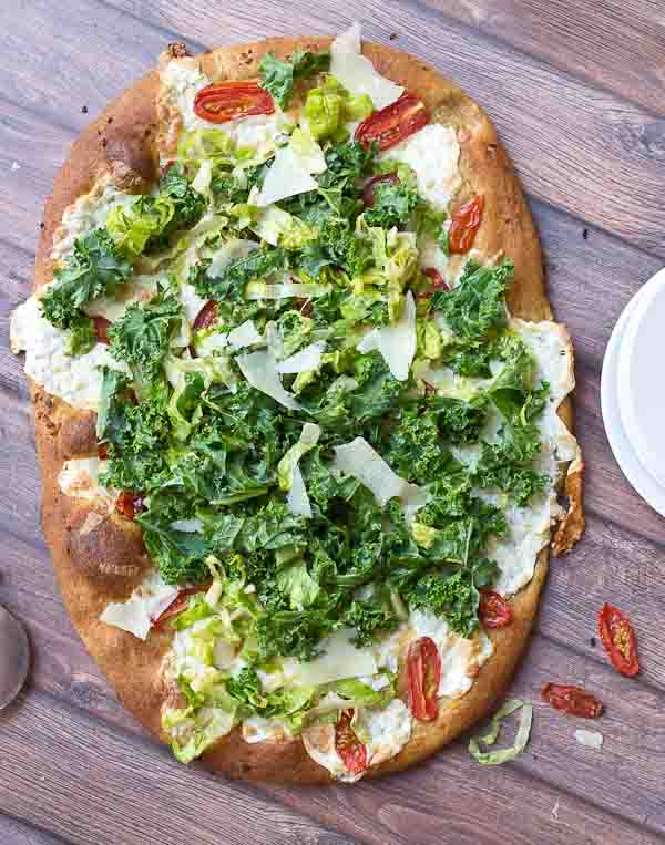 Get your Kale Caesar Salad Pizza on!! This pizza will be the talk of the town, a delicious Pizza blanca with roasted tomatoes, garlic and fresh mozzarella topped with loads of Kale Caesar Salad. 