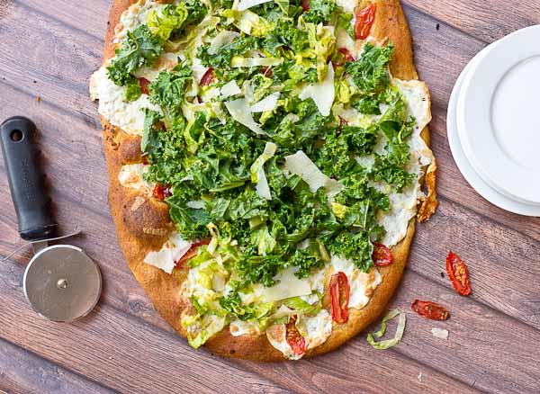 Get your Kale Caesar Salad Pizza on!! This pizza will be the talk of the town, a delicious Pizza blanca with roasted tomatoes, garlic and fresh mozzarella topped with loads of Kale Caesar Salad. 