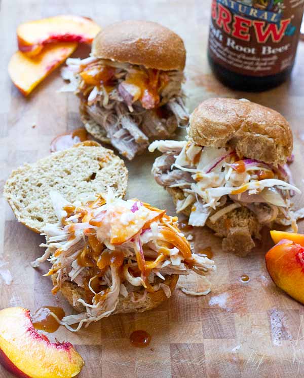 Root Beer Pulled Pork with Peach Slaw made in the slow cooker just in time for game day! This recipe has a simple ingredient list and that Homemade BBQ Sauce and those peaches in that Peach Slaw, you can't miss out on that sweetness. YUM!