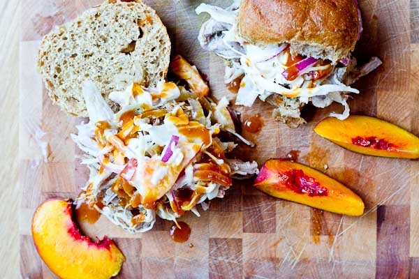 Root Beer Pulled Pork with Peach Slaw made in the slow cooker just in time for game day! This recipe has a simple ingredient list and that Homemade BBQ Sauce and those peaches in that Peach Slaw, you can't miss out on that sweetness. YUM!