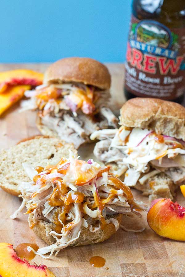 Root Beer Pulled Pork with Peach Slaw made in the slow cooker just in time for game day! This recipe has a simple ingredient list and that Homemade BBQ Sauce and those peaches in that Peach Slaw, you can't miss out on that sweetness. YUM!