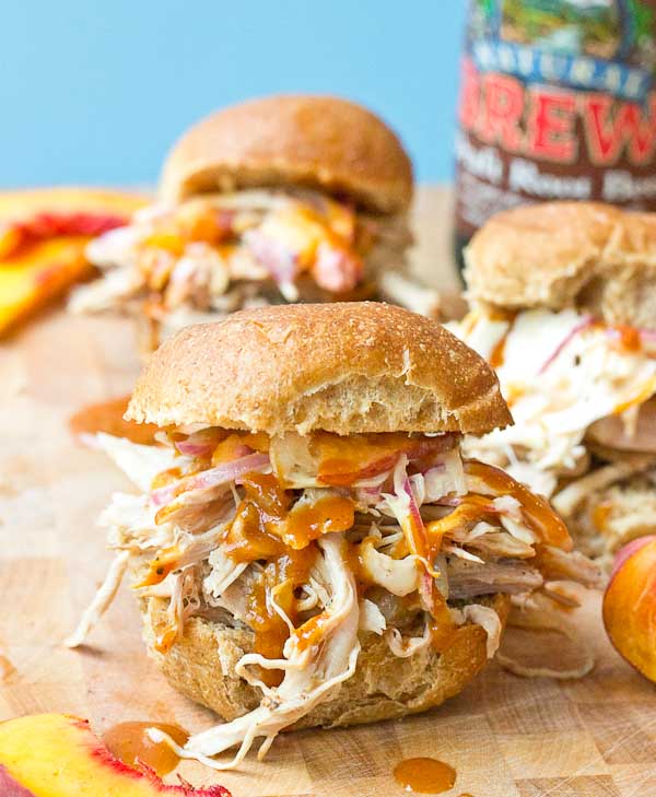 Root Beer Pulled Pork with Peach Slaw made in the slow cooker just in time for game day! This recipe has a simple ingredient list and that Homemade BBQ Sauce and those peaches in that Peach Slaw, you can't miss out on that sweetness. YUM!