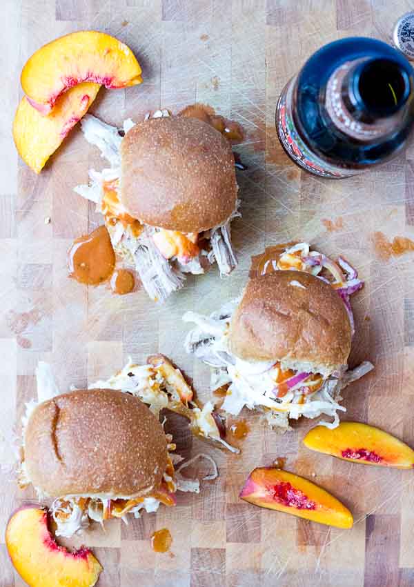 Root Beer Pulled Pork with Peach Slaw made in the slow cooker just in time for game day! This recipe has a simple ingredient list and that Homemade BBQ Sauce and those peaches in that Peach Slaw, you can't miss out on that sweetness. YUM!