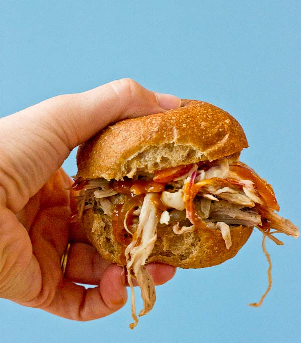 Root Beer Pulled Pork with Peach Slaw made in the slow cooker just in time for game day! This recipe has a simple ingredient list and that Homemade BBQ Sauce and those peaches in that Peach Slaw, you can't miss out on that sweetness. YUM!