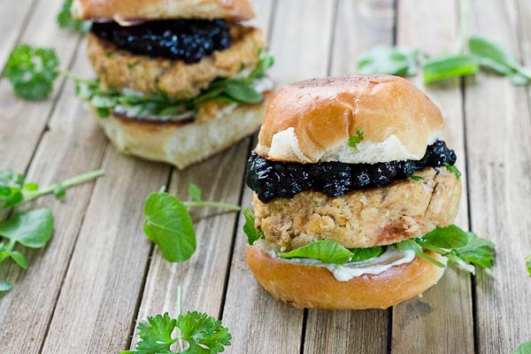 These Salmon Sliders with Blueberry Compote are quite possibly the best way to eat salmon at home! Convenience, price, and deliciousness! Warm salmon cakes, wild blueberries compote, maple goat cheese spread, toasted buttery buns = BEST FOOD EVER.