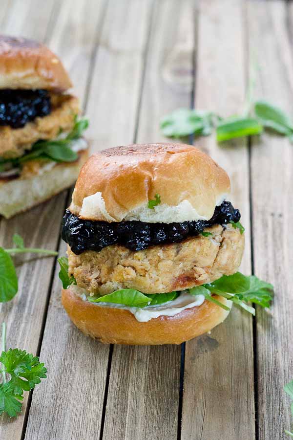 These Salmon Sliders with Blueberry Compote are quite possibly the best way to eat salmon at home! Convenience, price, and deliciousness! Warm salmon cakes, wild blueberries compote, maple goat cheese spread, toasted buttery buns = BEST FOOD EVER.