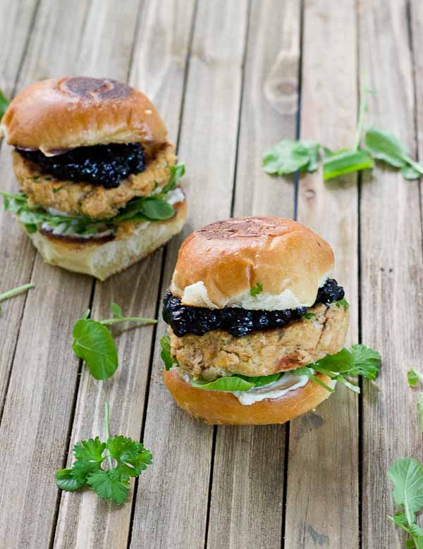 These Salmon Sliders with Blueberry Compote are quite possibly the best way to eat salmon at home! Convenience, price, and deliciousness! Warm salmon cakes, wild blueberries compote, maple goat cheese spread, toasted buttery buns = BEST FOOD EVER.