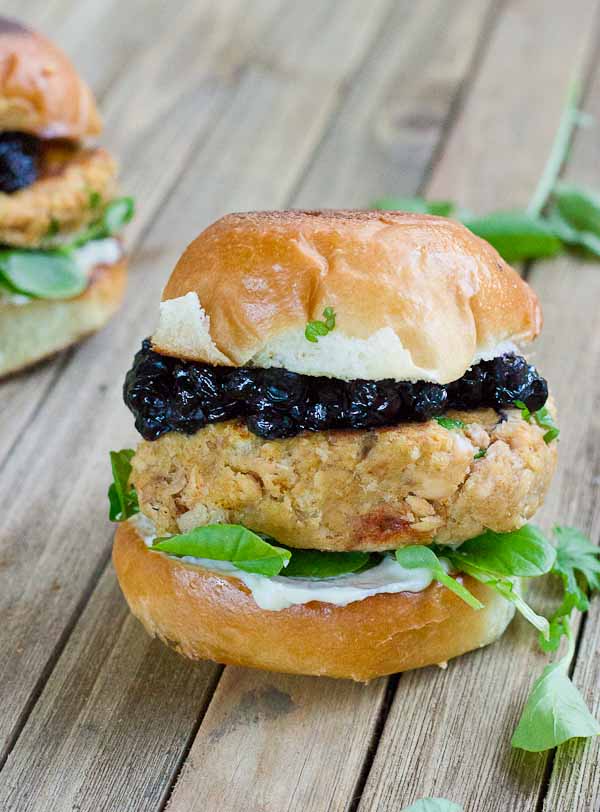 These Salmon Sliders with Blueberry Compote are quite possibly the best way to eat salmon at home! Convenience, price, and deliciousness! Warm salmon cakes, wild blueberries compote, maple goat cheese spread, toasted buttery buns = BEST FOOD EVER.