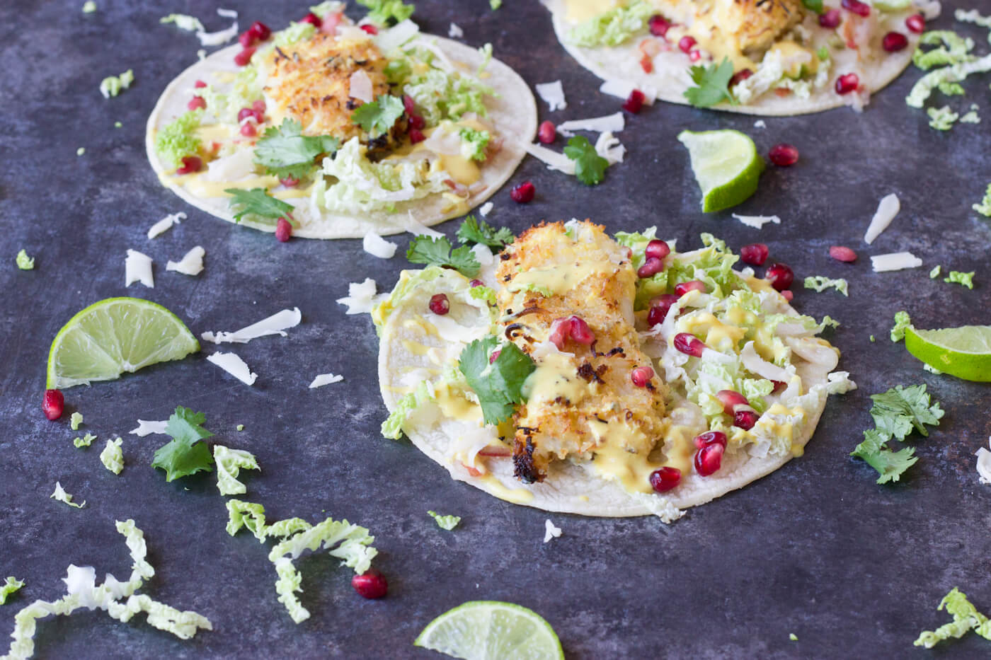 Crazy for tacos? Add these Crispy Fish Tacos to your menu! Crispy baked cod topped with pomegranates, shredded pear, and Honey Lime Crema. Simple to make at home!