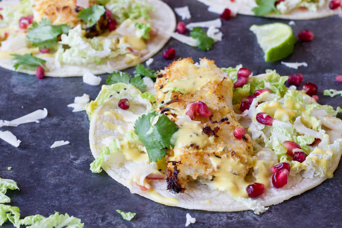 Crazy for tacos? Add these Crispy Fish Tacos to your menu! Crispy baked cod topped with pomegranates, shredded pear, and Honey Lime Crema. Simple to make at home!