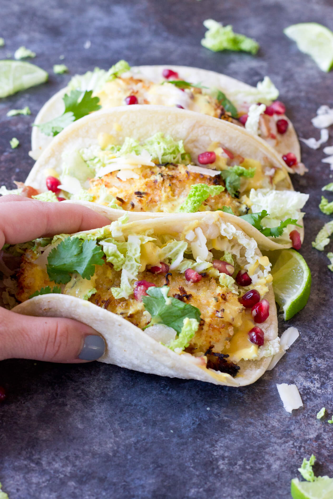 Crazy for tacos? Add these Crispy Fish Tacos to your menu! Crispy baked cod topped with pomegranates, shredded pear, and Honey Lime Crema. Simple to make at home!