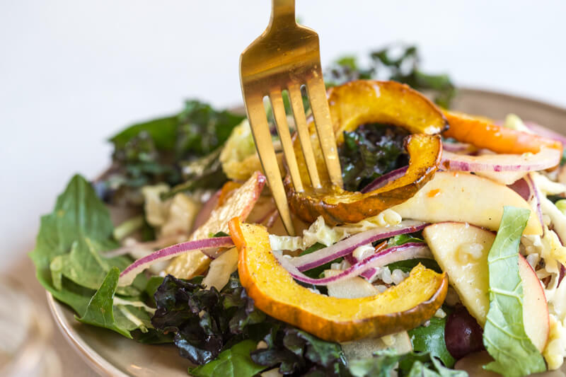 This Winter Greens Salad with Citrus Vinaigrette tho. It's exactly what should be on your holiday table--- warm acorn squash, apple slaw, winter greens, hearty grains and a tangy citrus vinaigrette! Add grilled chicken or garbanzo beans to make this salad a meal, or serve as a salad in your holiday spread.