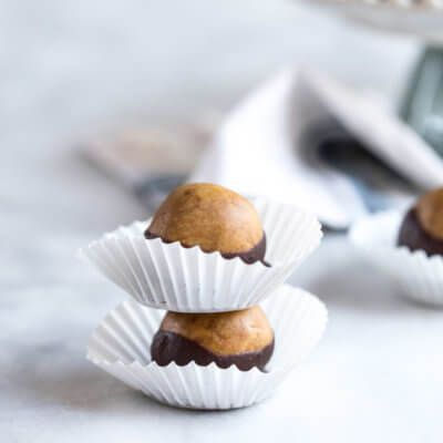 Healthy Peanut Butter Buckeyes my friends. This snack is high in protein and made with peanut butter (duh), peanut butter powder, a touch of maple syrup and dipped in dark chocolate!