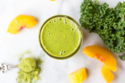 Go green with this mighty Matcha Green Tea Smoothie made with frozen mango, peaches, kale, orange juice, kefir, and matcha green tea powder. It's antioxidant rich, smooth and creamy and makes a great breakfast or snack!