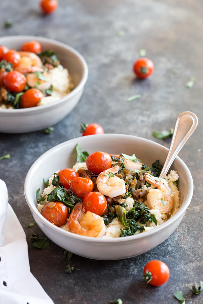 Shrimp and Cheesy Cauliflower Grits, a low carb southern breakfast. Cheesy cauliflower grits topped with savory shrimp, bacon, a hearty dose of kale, and blistered cherry tomatoes. 