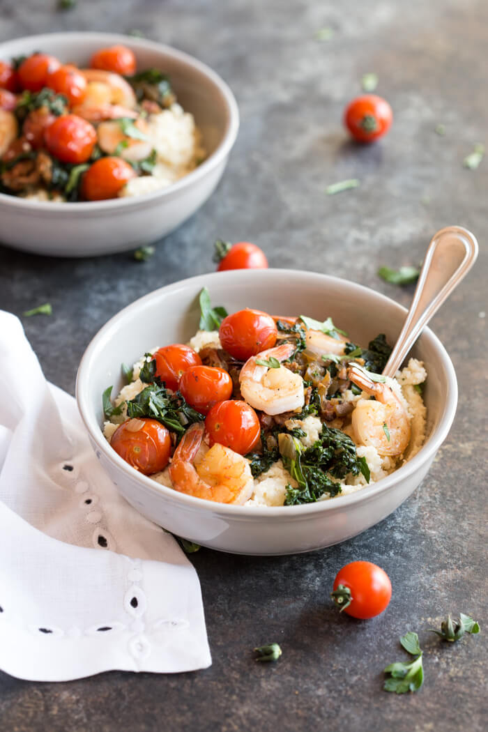 Shrimp and Cheesy Cauliflower Grits, a low carb southern breakfast. Cheesy cauliflower grits topped with savory shrimp, bacon, a hearty dose of kale, and blistered cherry tomatoes. 