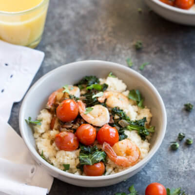 Shrimp and Cherry Tomatoes over Cheesy Cauliflower Grits, a low carb southern breakfast. Cheesy cauliflower grits topped with savory shrimp, bacon, a hearty dose of kale, and blistered cherry tomatoes thanks to Village Farms Cherry no. 9 Fall in Love Again tomatoes.