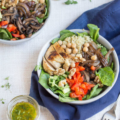 bowl is topped with grilled chicken, sautéed onions and mushrooms and a zesty herb dressing.